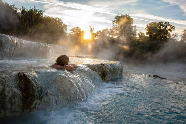 Persona che si rilassa in una sorgente termale naturale in Toscana, immagine illustrativa a tema benessere